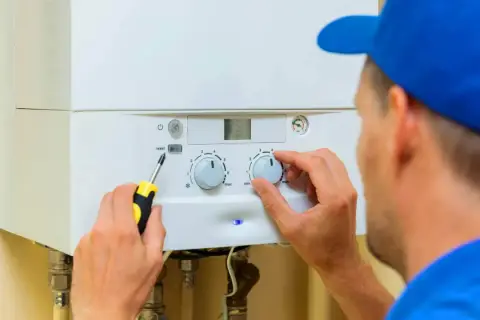 Technik reguluje piec gazowy. Regularny przegląd pieca gazowego co ile zapewnia jego sprawność i bezpieczeństwo.